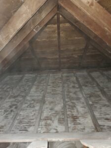 Attic insulation before replacement by Better World Builders.