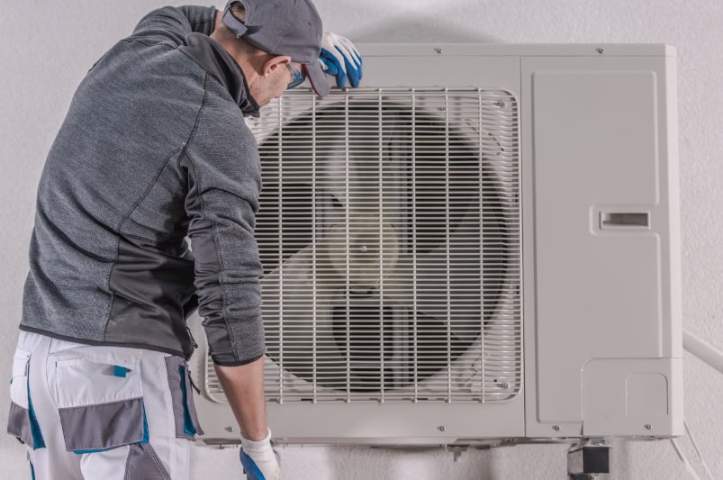 Modern Heat Pump Repair by Caucasian Technician in His 30s. House Heating Technologies.