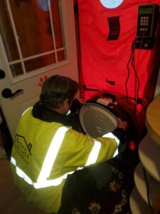 image of Better World Builders owner, Mark Lee, conducting a new construction Blower Door test.
