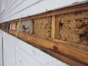 Image of old, failed wall insulation.