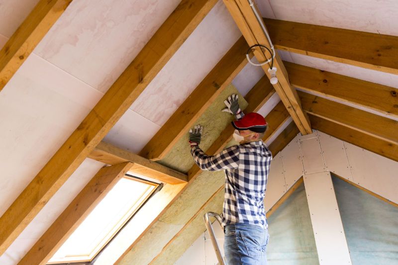 Image of someone installing insulation. Do I Need Ceiling Insulation?